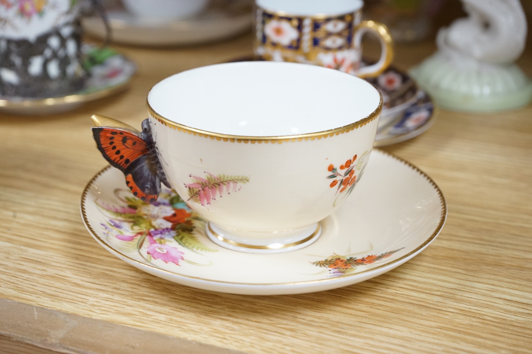 A Worcester butterfly handled cup and saucer and four other items, together with Royal Crown Derby, Dresden and Coalport items. (9). Tallest 13 cm